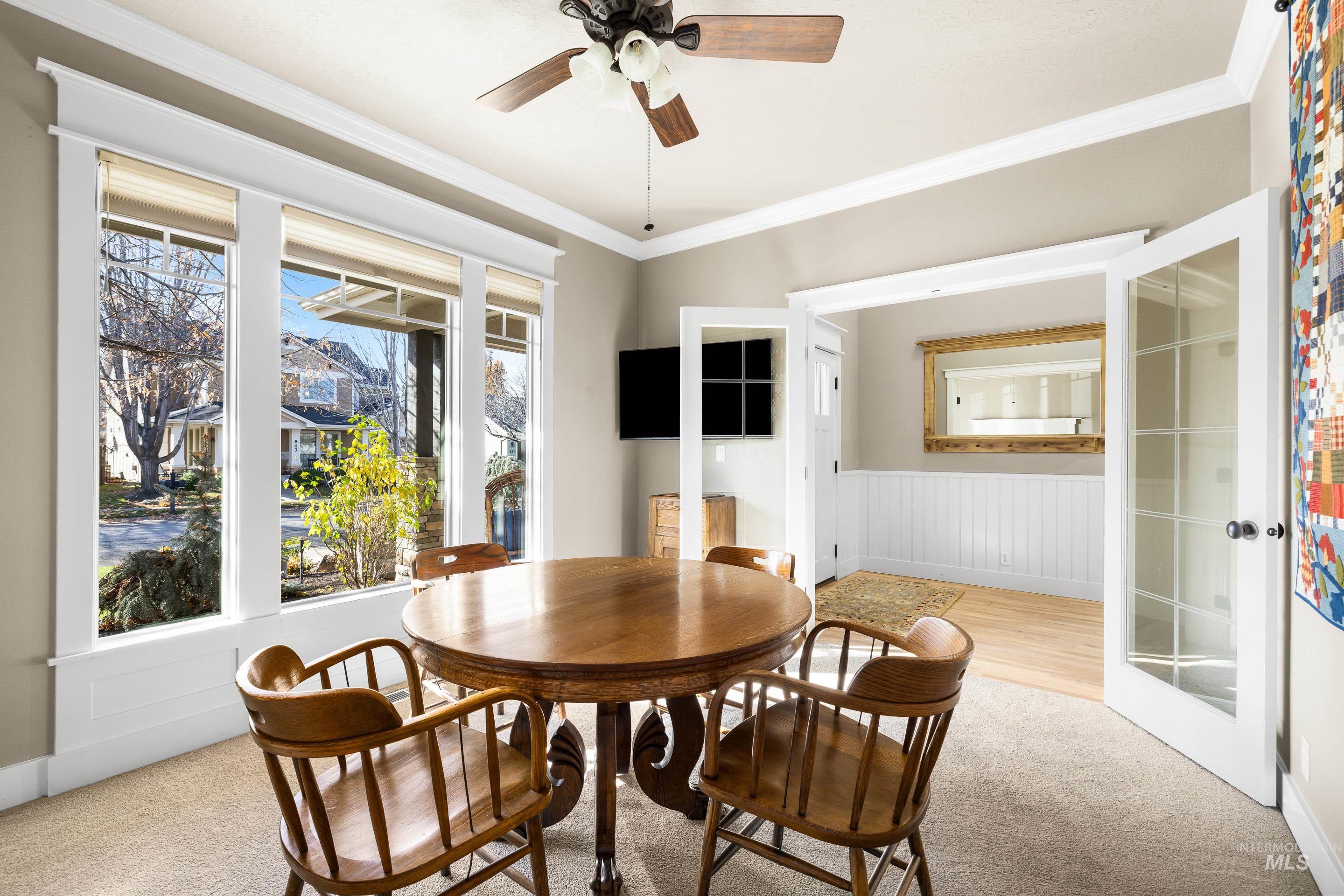 836 West Colbert Street Meridian, ID 83646 - Photo 8 of 45 Dining room featuring light colored carpet, crown molding, ceiling fan, and wainscoting