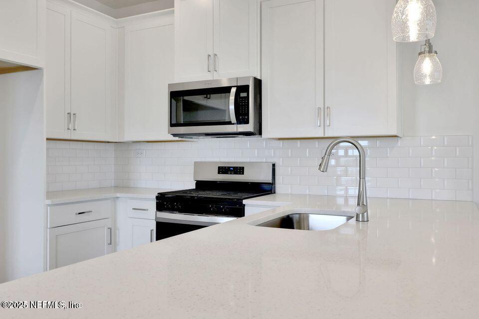 36 Thurnham Lane St. Augustine, FL 32092 - Photo 4 of 15 a kitchen with white cabinets a sink and stainless steel appliances