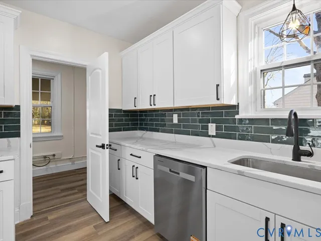a kitchen with stainless steel appliances granite countertop a sink a stove and cabinets
