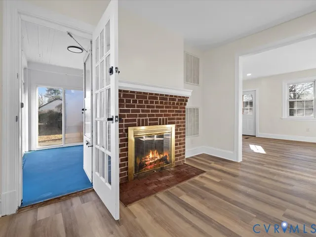 a view of a livingroom with wooden floor and a fireplace