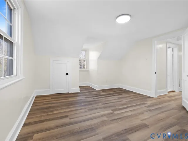 a view of empty room with wooden floor