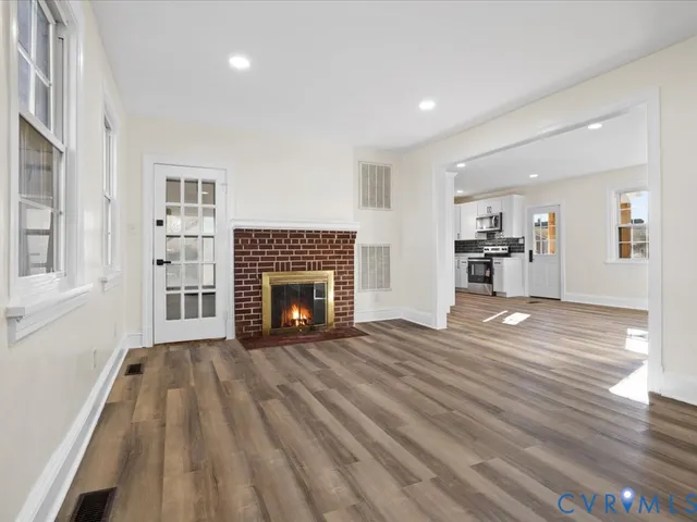 a view of empty room with wooden floor and fireplace