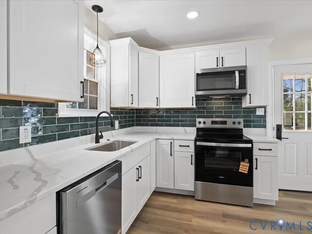 a kitchen with stainless steel appliances granite countertop a sink stove and cabinets