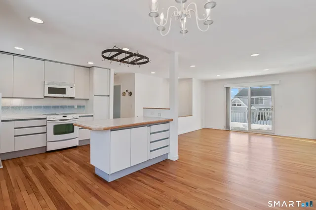 a room with wooden floor and chandelier