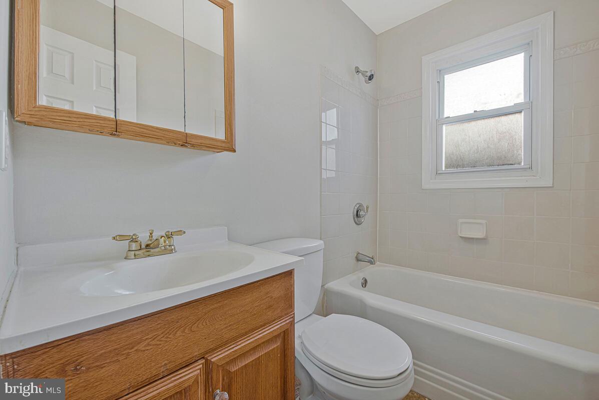 7712 Frederick Road Hyattsville, MD 20784 - Photo 11 of 30 a bathroom with a sink a toilet and bathtub