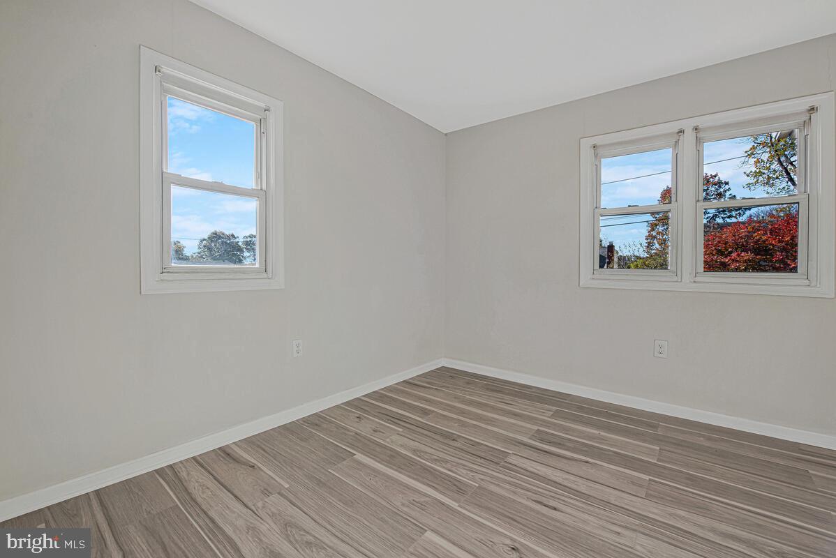 7712 Frederick Road Hyattsville, MD 20784 - Photo 12 of 30 a view of empty room with wooden floor and fan