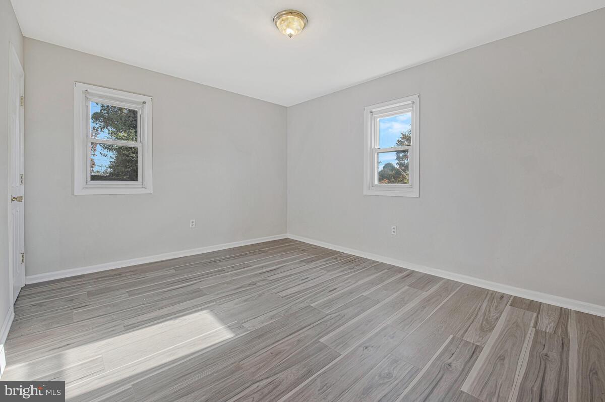 7712 Frederick Road Hyattsville, MD 20784 - Photo 13 of 30 a view of an empty room with wooden floor and a window