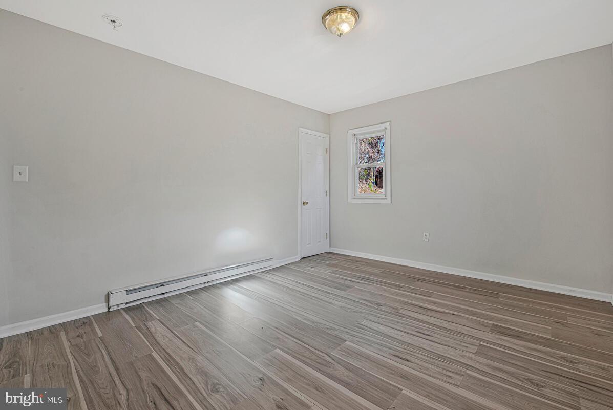 7712 Frederick Road Hyattsville, MD 20784 - Photo 16 of 30 an empty room with wooden floor