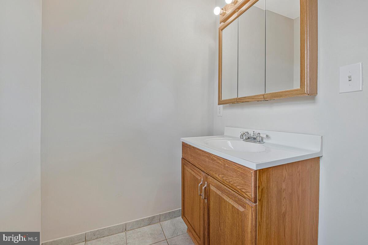 7712 Frederick Road Hyattsville, MD 20784 - Photo 17 of 30 a utility room with a sink a vanity and mirror