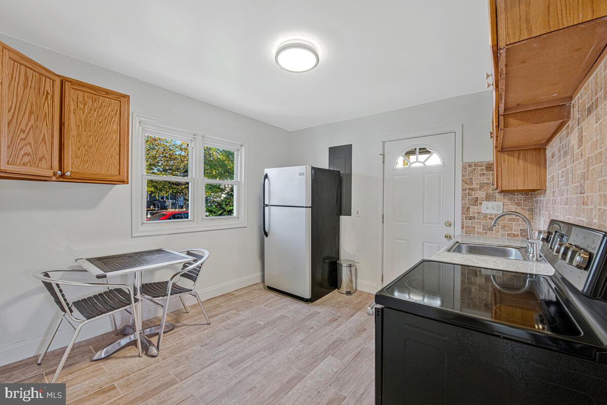 7712 Frederick Road Hyattsville, MD 20784 - Photo 6 of 30 a kitchen that has a refrigerator and a chair in it