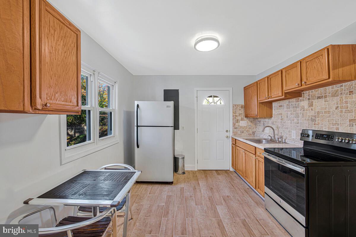 7712 Frederick Road Hyattsville, MD 20784 - Photo 7 of 30 a kitchen with a refrigerator and a stove top oven