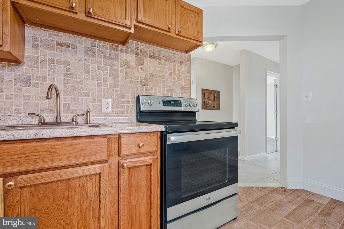 7712 Frederick Road Hyattsville, MD 20784 - Photo 10 of 30 a kitchen with stainless steel appliances granite countertop a stove a sink and a microwave