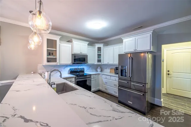 a kitchen with granite countertop a refrigerator stove and microwave