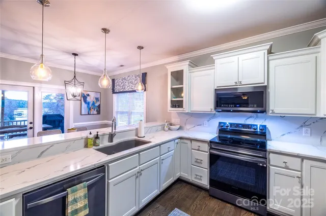 a kitchen with stainless steel appliances granite countertop a stove a sink and a microwave