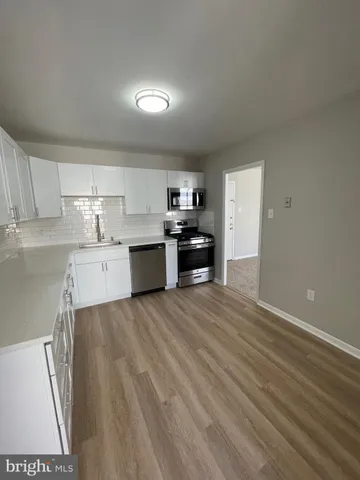 a kitchen with granite countertop a refrigerator and a sink