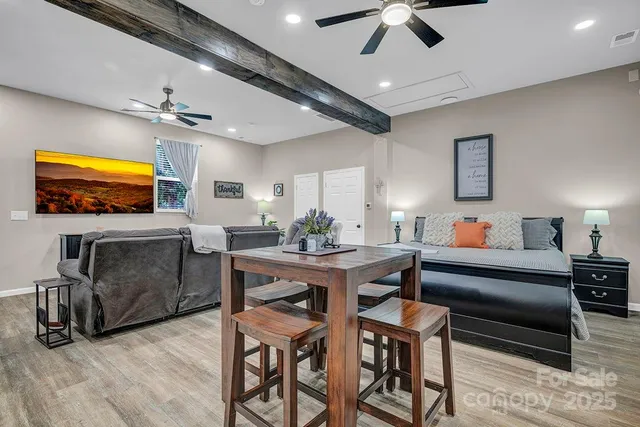a view of a backyard with table and chairs potted plants and large tree