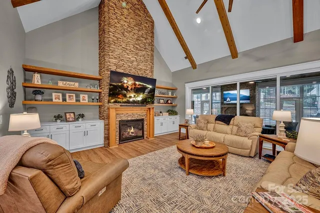 a living room with furniture a fireplace and a large window