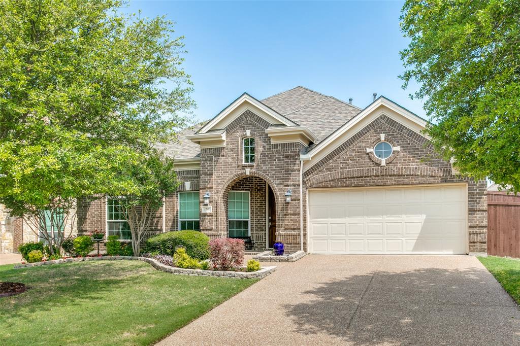 a front view of a house with a garden and yard
