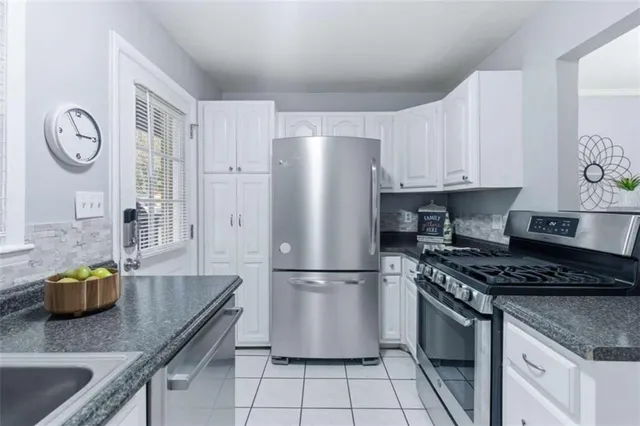 a kitchen with granite countertop a refrigerator and a stove top oven