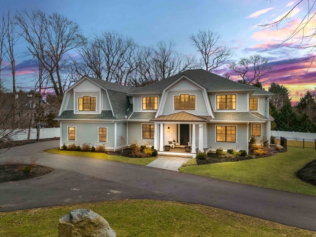 a front view of a house with a garden and trees