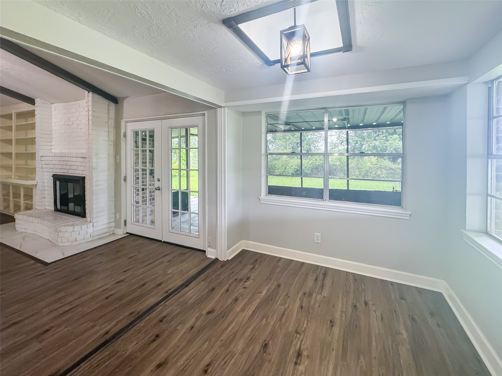 912 Robinson Road La Porte, TX 77571 - Photo 13 of 39 an empty room with wooden floor fireplace and windows