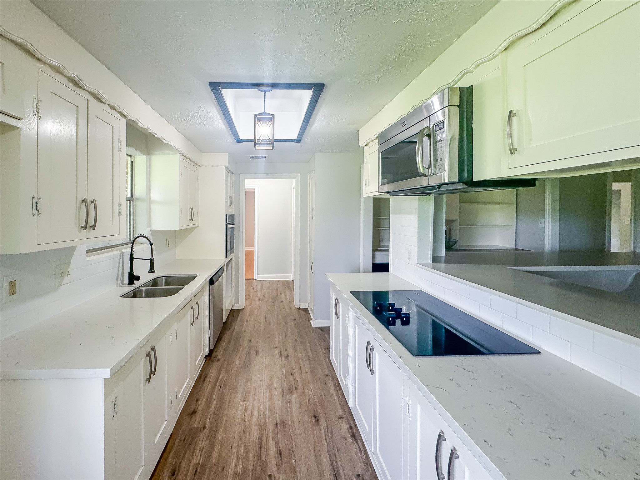 912 Robinson Road La Porte, TX 77571 - Photo 14 of 39 a large white kitchen with stainless steel appliances granite countertop a lot of counter space and wooden floors