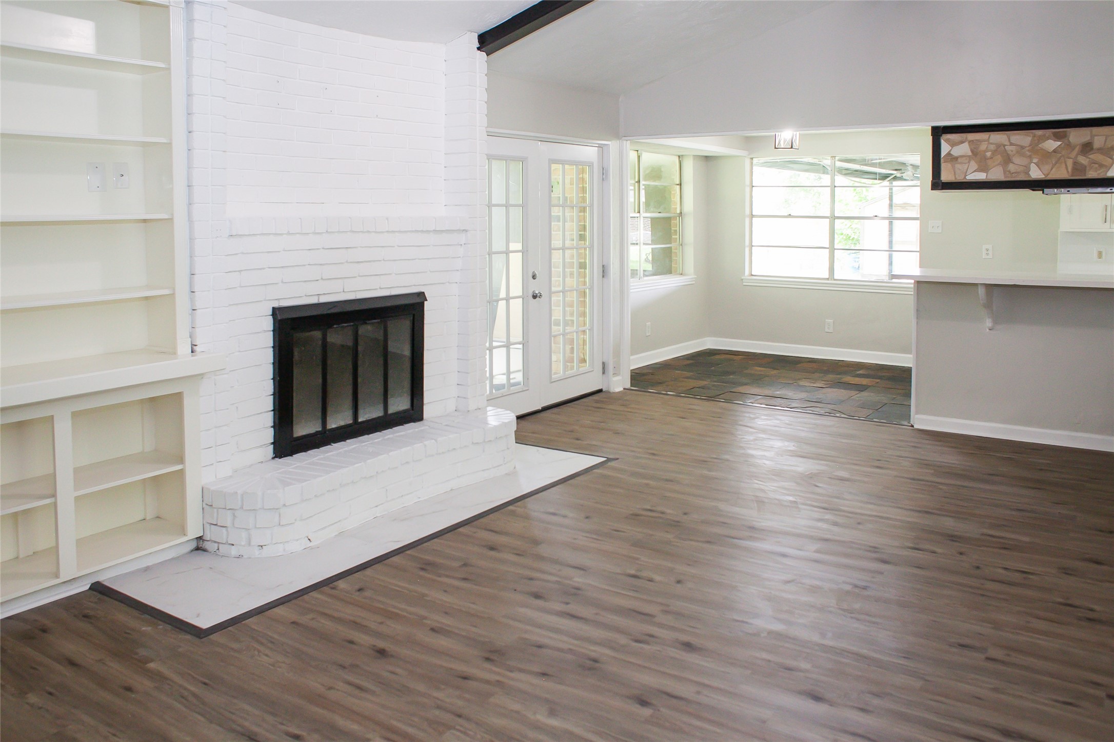 912 Robinson Road La Porte, TX 77571 - Photo 19 of 39 an empty room with wooden floor fireplace and windows