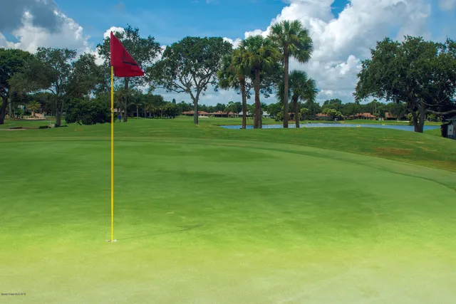 a flag is sitting in the grass with large trees