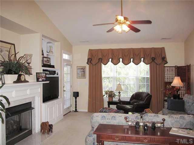 10472 Dapping Drive Raleigh, NC 27614 - Photo 3 of 12 a living room with furniture a fireplace and a chandelier