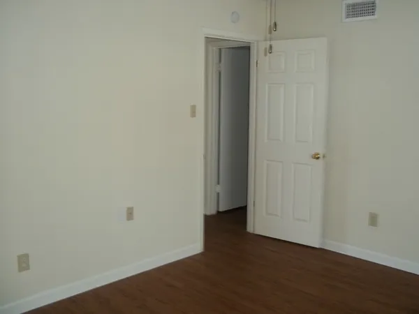 a view of an empty room with wooden floor