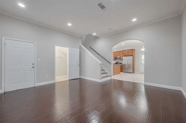 an empty room with wooden floor and entryway