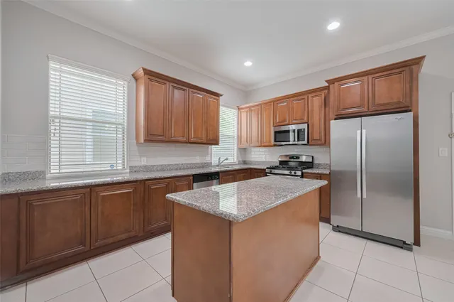 a kitchen with stainless steel appliances granite countertop a sink counter space cabinets and a large window