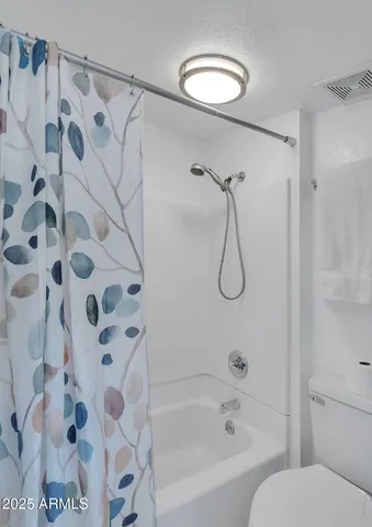 a bathroom with a toilet and a shower curtain