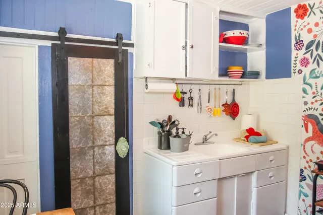 a kitchen with a refrigerator and white cabinets