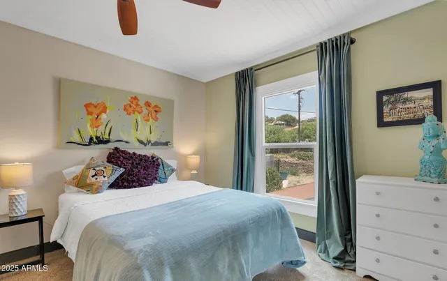 a bedroom with a bed and a painting on the wall