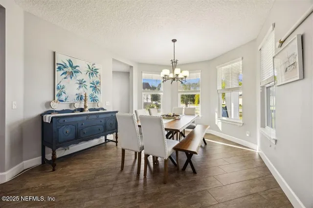 a view of a dining room with furniture and chandelier