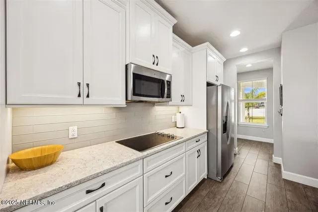a kitchen with stainless steel appliances granite countertop a sink a stove and a refrigerator