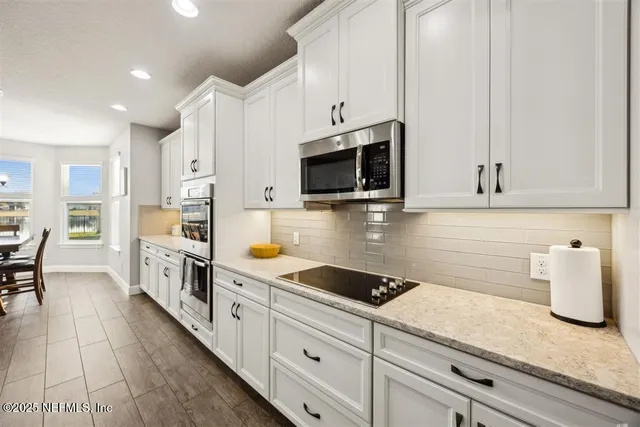 a kitchen with stainless steel appliances white cabinets a sink and dishwasher