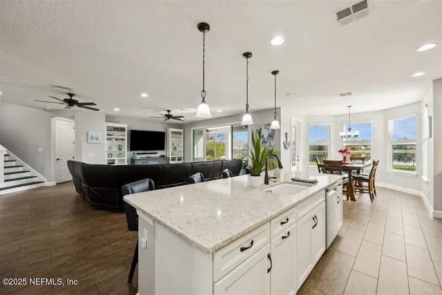 a kitchen with stainless steel appliances kitchen island granite countertop a table chairs and a stove