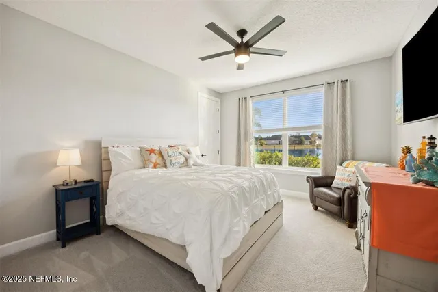 a bedroom with a bed a flat screen tv and a couch