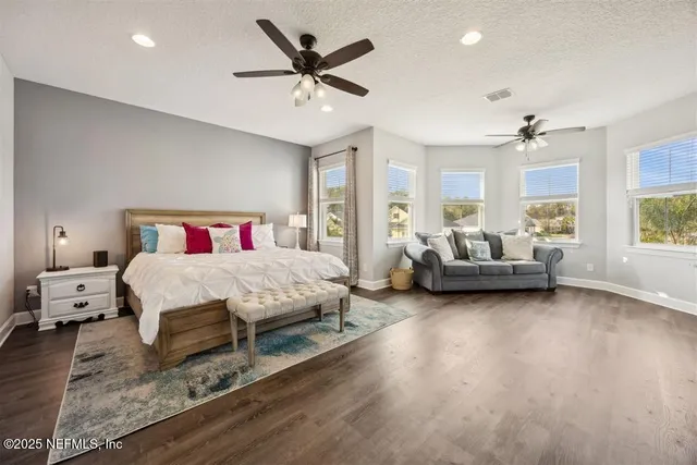 a spacious bedroom with a bed a couch and a window