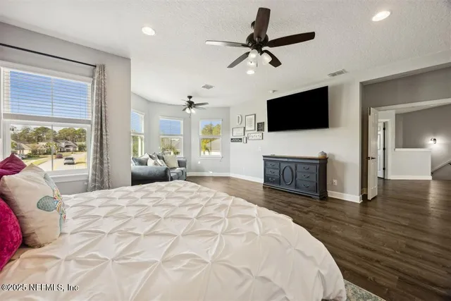 a bedroom with a bed a flat screen tv and a fireplace