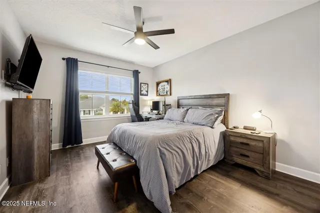 a bedroom with a bed window and a flat screen tv