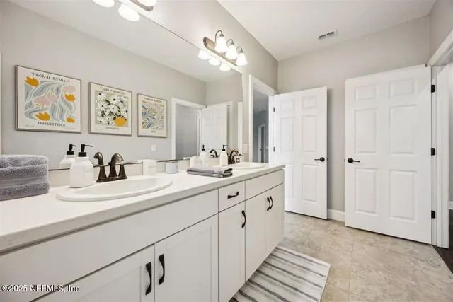 a spacious bathroom with a double vanity sink mirror and double