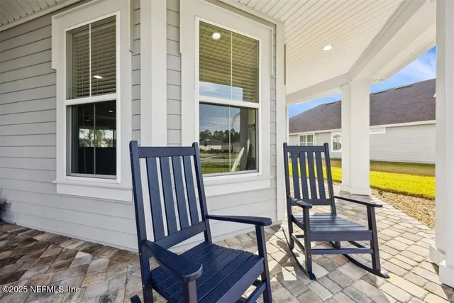 a view of balcony with two chairs and a potted plant