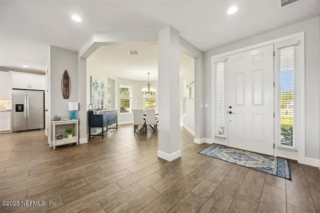 a view of a livingroom with entryway and wooden floor