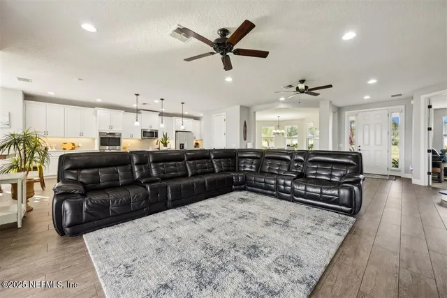 a living room with furniture and kitchen view