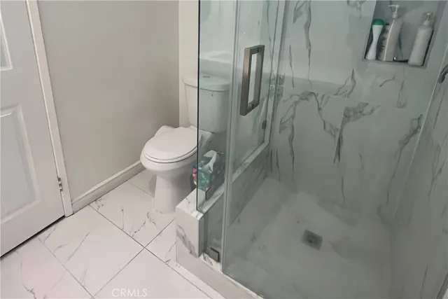 a bathroom with a toilet and a shower