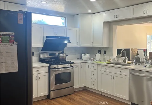 a kitchen with granite countertop white cabinets and white appliances