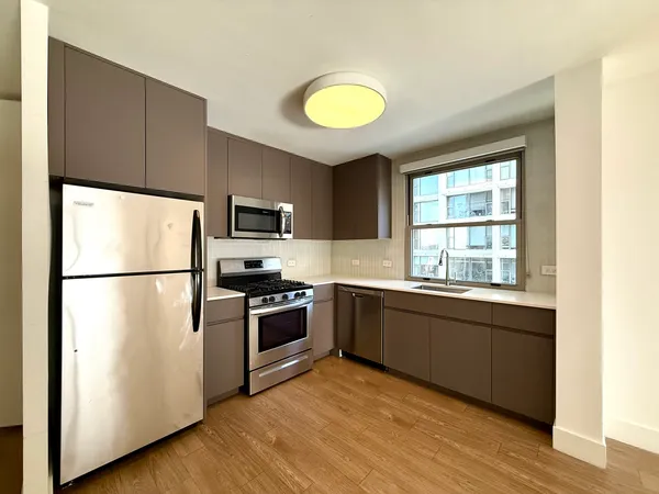 a kitchen with a refrigerator and a stove top oven